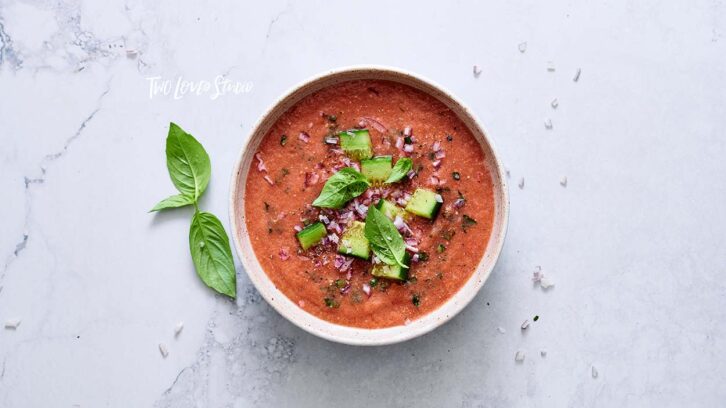 A bowl of gazpacho on a marble background.